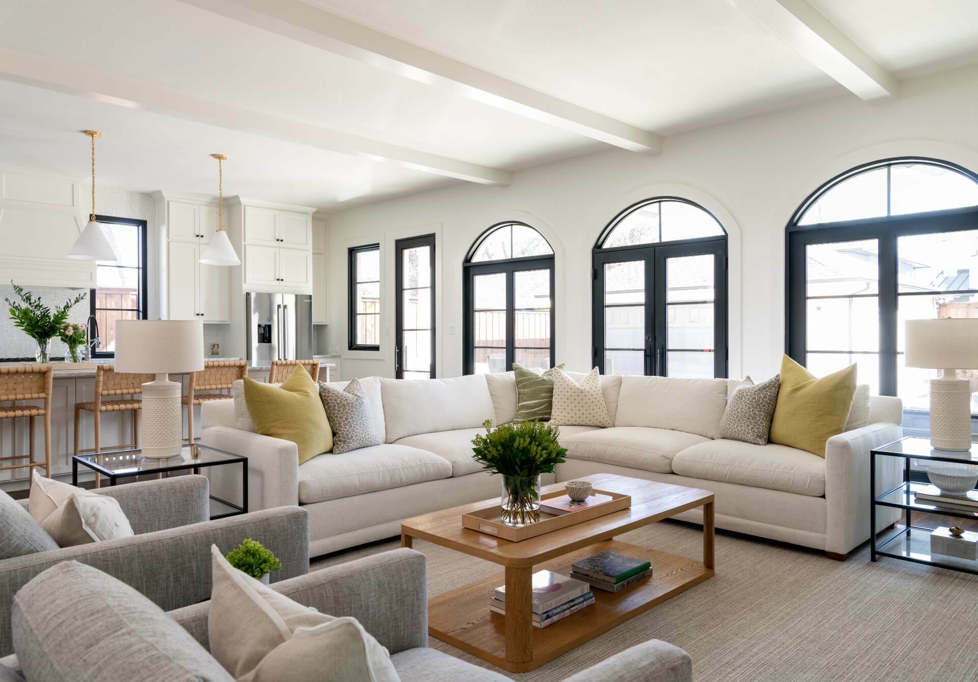 View of living room, white section sofa, large bay windows, and counter bar seating area.