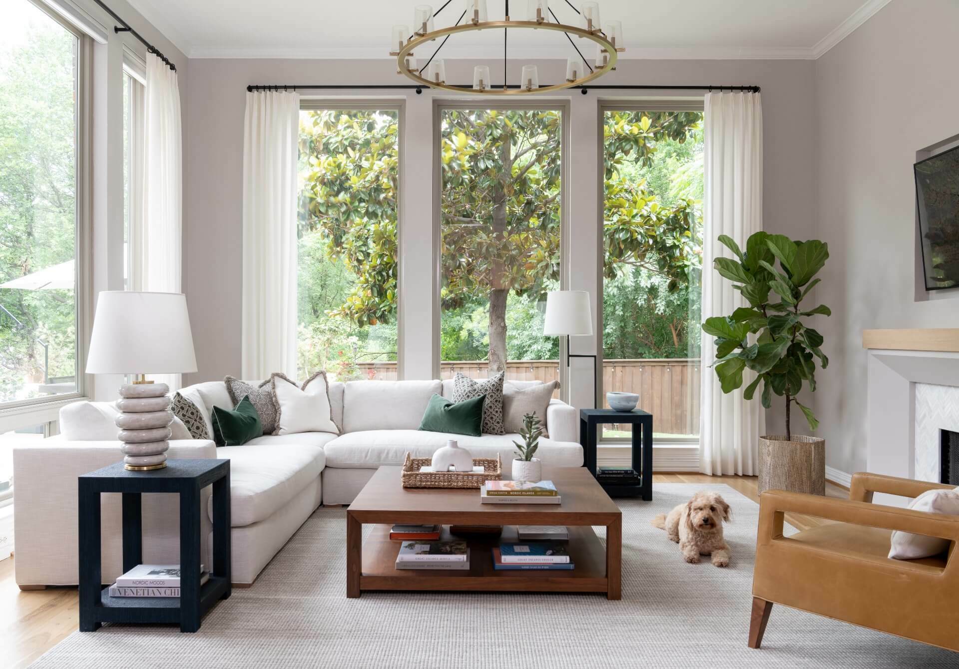 View of living room with white sectional sofa, leather lounge chair, and dog lying on rug