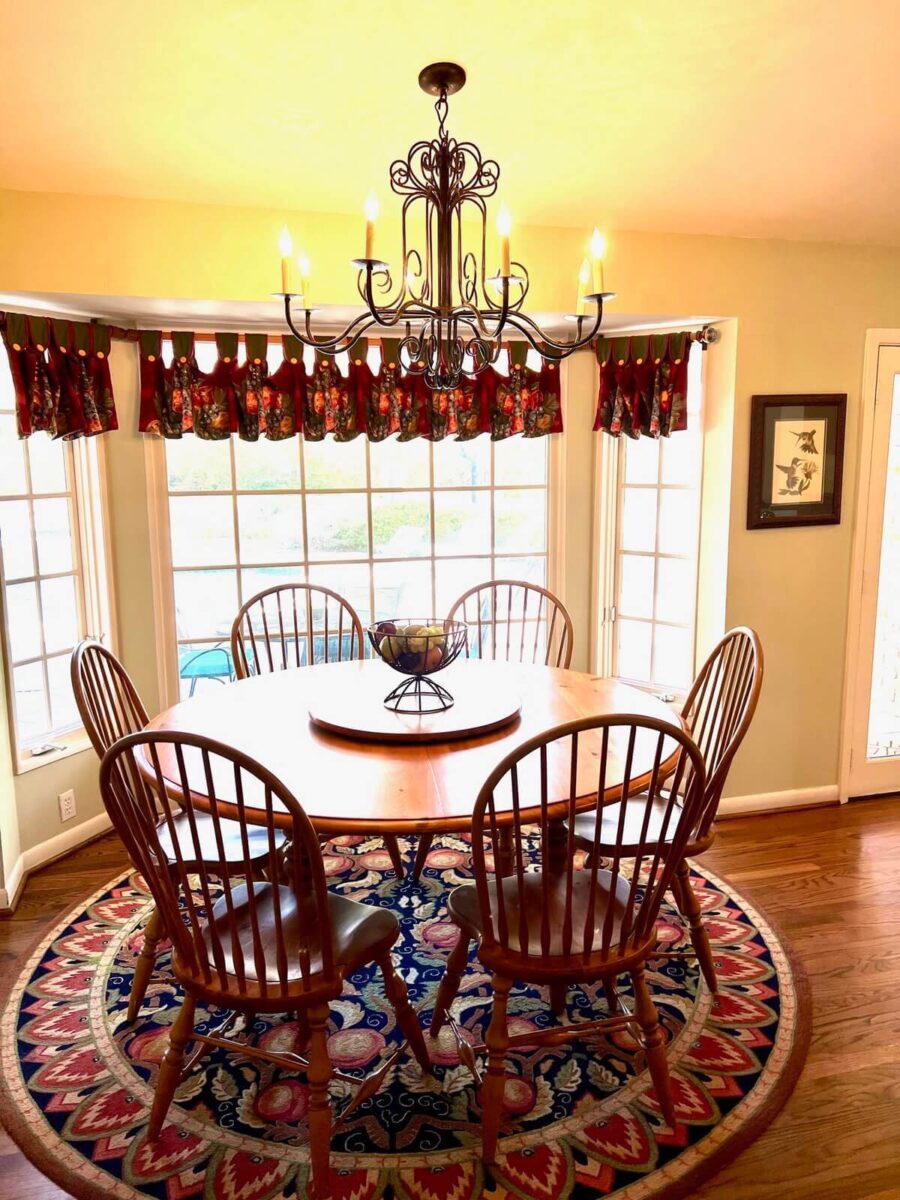 Photo of dining area before redesign with wooden chairs and antiqued light fixture