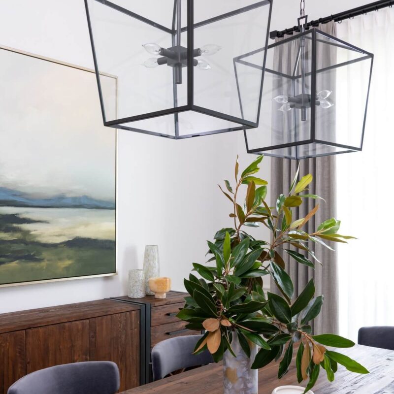 Close up of dining table top with flowers on table and pendant lamps hanging above